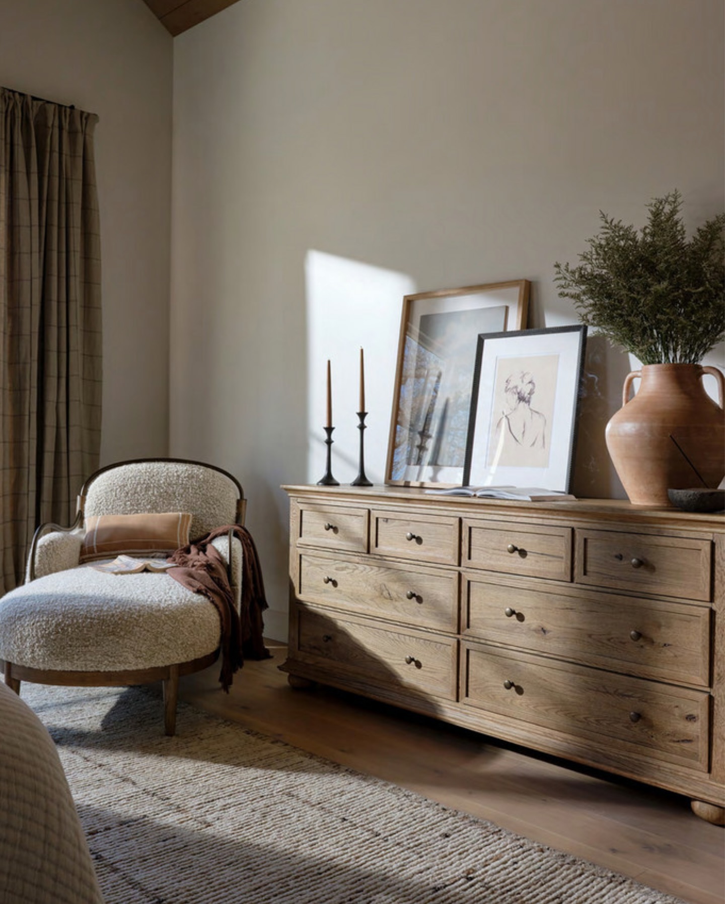Staged bedroom with chaise lounge, dresser and decor
