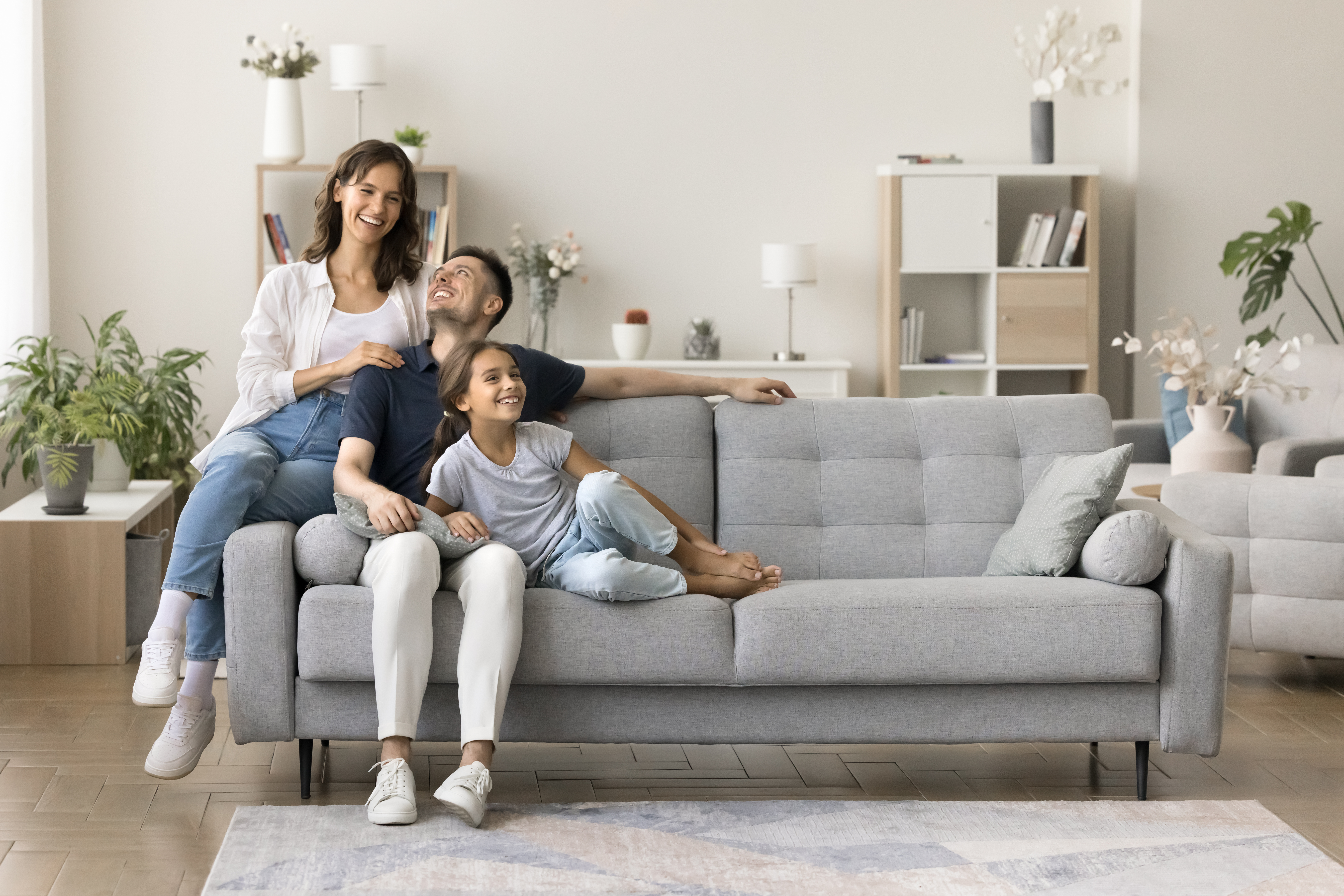Family sitting on couch of new home