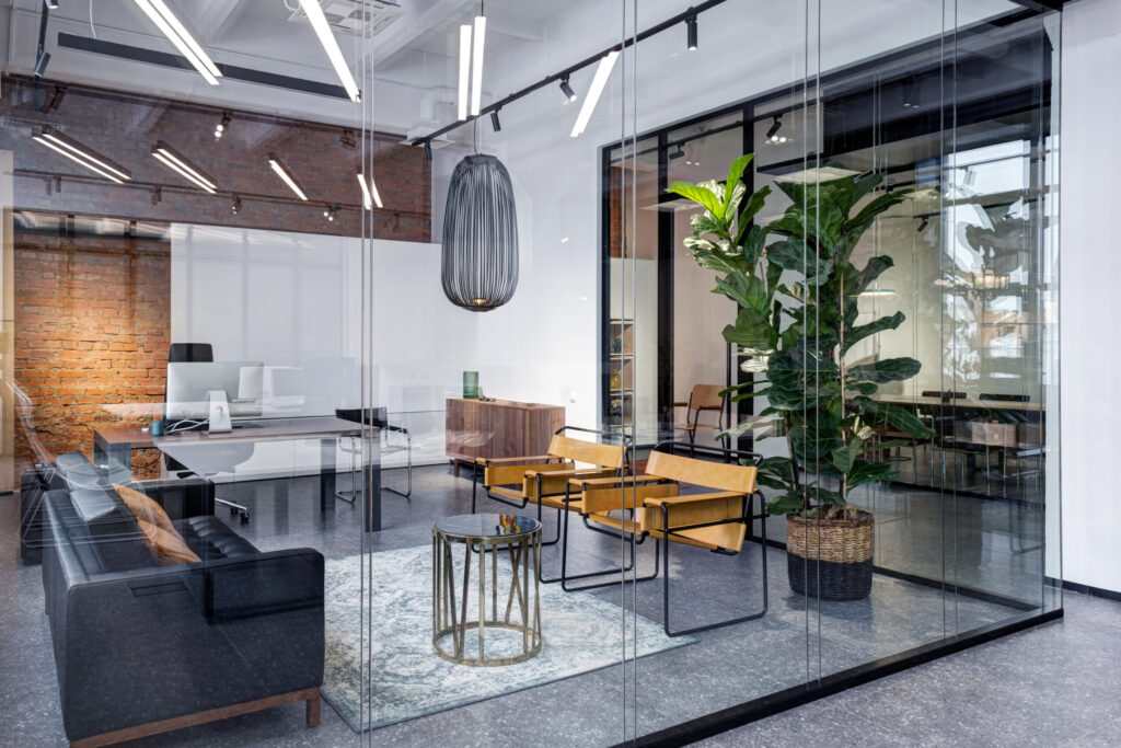 Example of a co-working office space with glass walls and modern office furniture